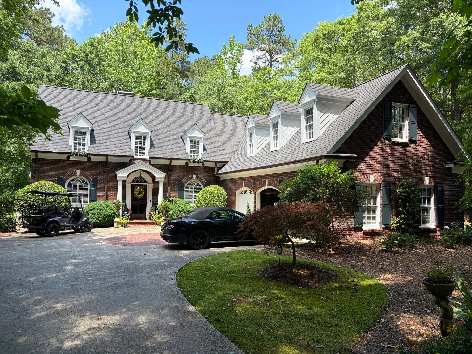 Freshly cleaned windows on a brick home with white dormers